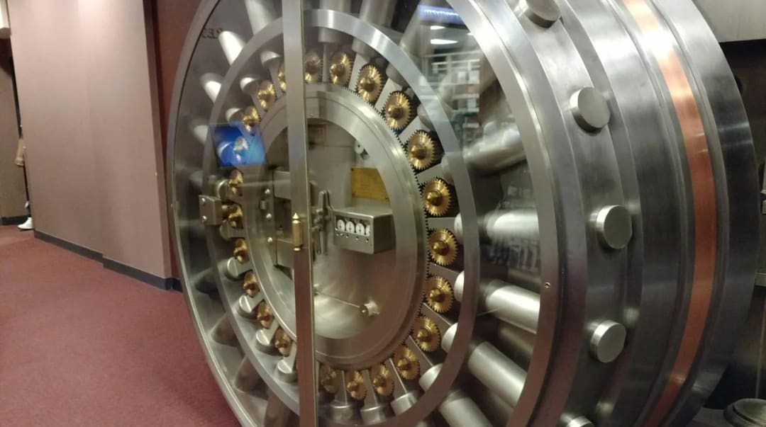 Masywne drzwi skarbca bankowego z mechanizmem ryglowym