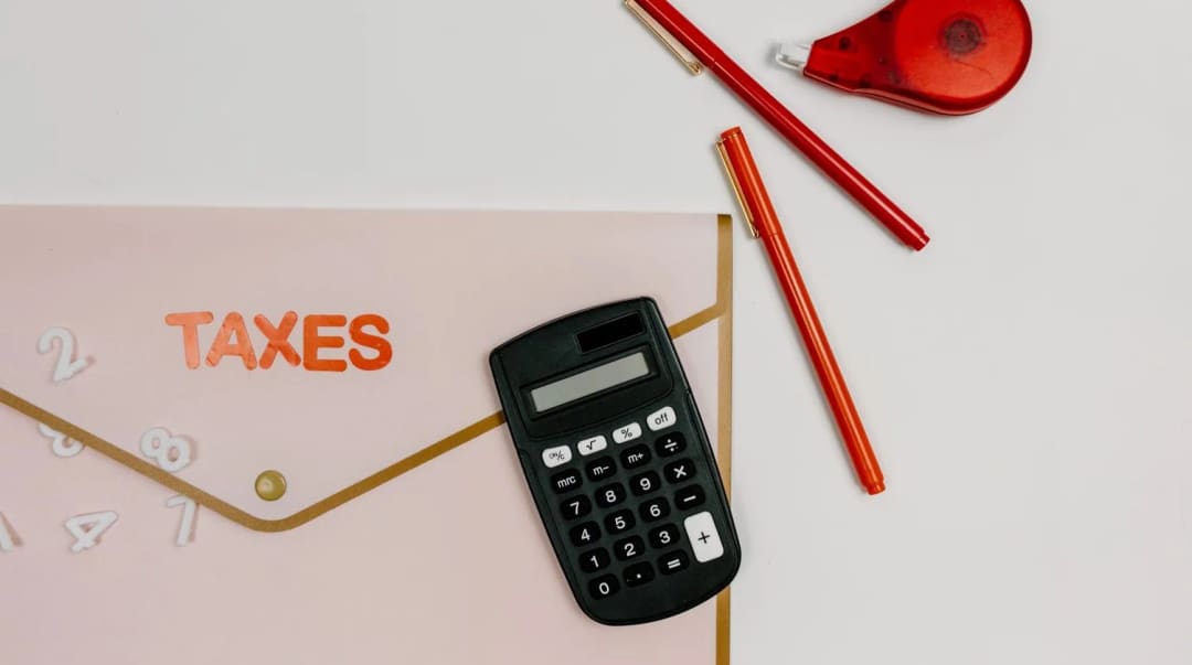 Koperta z napisem TAXES obok kalkulatora