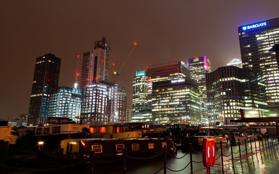 Nocna panorama drapaczy chmur londyńskiej dzielnicy finansowej Canary Wharf, symbol rynków, na których dziś to obligacje, a nie geopolityka, dyktują kierunek metali.