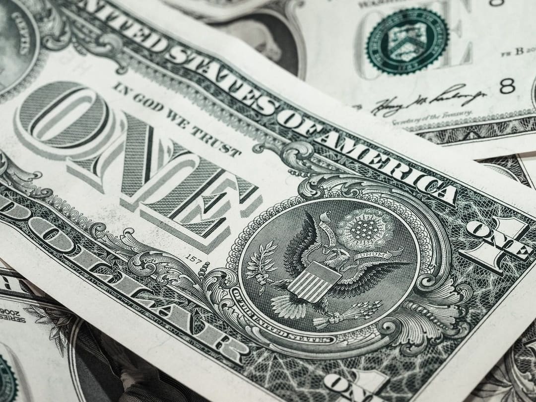 Banknoty dolarów amerykańskich ułożone jeden na drugim, w tle napięć wokół możliwej podwyżki stóp procentowych przez Fed
